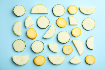 Fresh ripe cut zucchinis on light blue background, flat lay