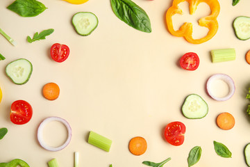 Frame made with fresh salad ingredients on beige background, flat lay. Space for text