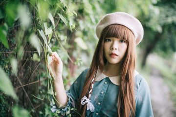 Portrait of asian girl in lolita fashion dress in garden background