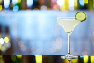 Glass of fresh alcoholic cocktail on bar counter. Space for text