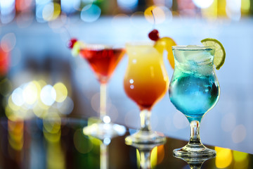 Glasses of fresh alcoholic cocktails on bar counter