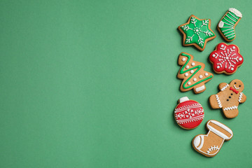 Flat lay composition with tasty homemade Christmas cookies on green background, space for text