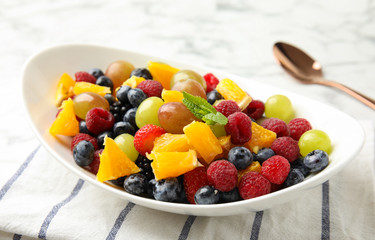 Fresh tasty fruit salad on table, closeup