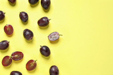 Flat lay composition with fresh ripe juicy grapes on yellow background, space for text