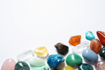 Different beautiful gemstones on white background, top view