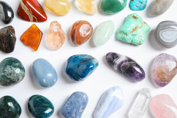Different beautiful gemstones on white background, top view
