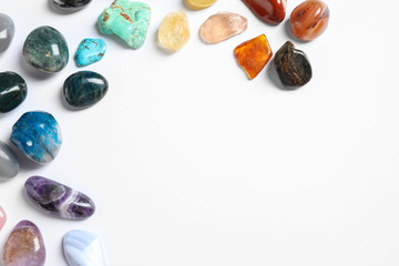 Different beautiful gemstones on white background, top view