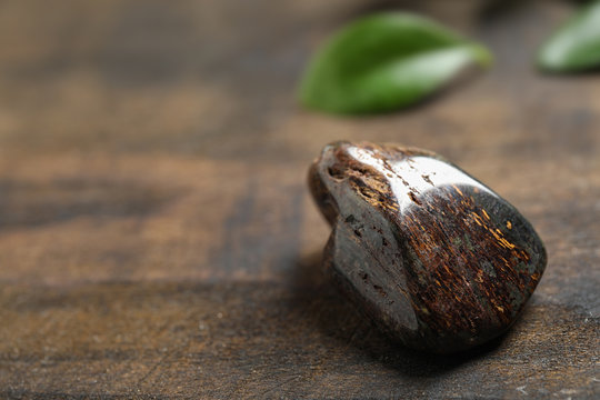 Beautiful brown bronzite gemstone on wooden table