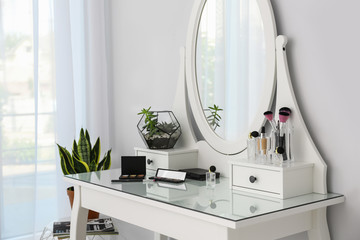 Cosmetics on dressing table with mirror at home. Stylish room interior