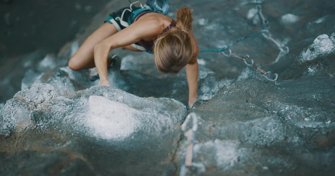 Strong focused woman lead rock climbing with power and style, cinematic slow motion rock climbing moments