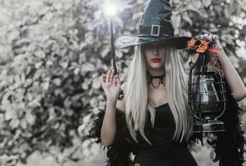 Halloween holiday witch Lady wear black hat and stylish dress in Mystical atmosphere outdoors, celebrate autumn 