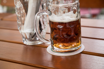 Glas dunkles Landbier oder Vollbier Bier in Biergarten auf Holz Tisch im Sommer