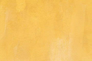 Yellow color painted rough polished cement wall, concrete texture background.
