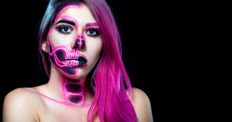 Halloween. Woman in day of the dead mask skull face art. Pink and black skull make up.