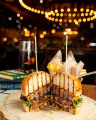 juicy cheeseburger cut in half on a wooden board