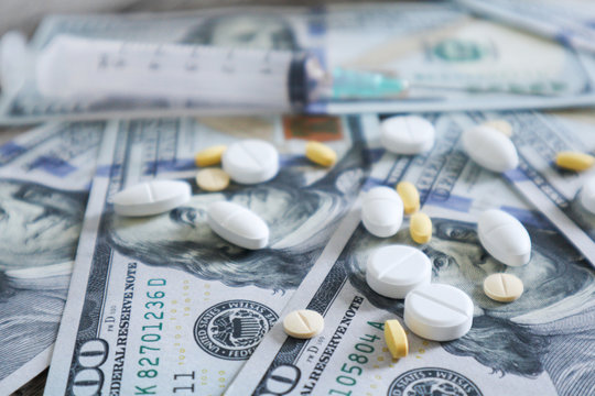 medicine pill and syringe on 100 dollar banknote background.Healthcare insurance and medical treatment cost concept