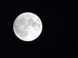 An amazing photography of the full moon over the city of Genova by night with a great clear sky in background and some stars