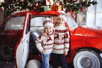Two boys near a red retro car. Christmas, New Year concept.