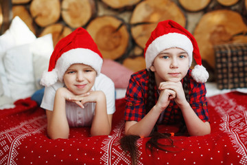 Girl and boy teenager in a red Christmas hats.