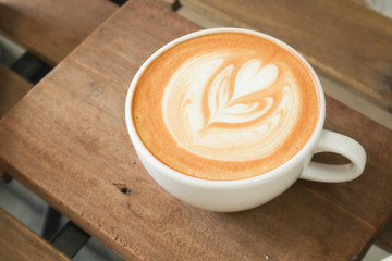 Coffee cup with latte art foam on wood table in coffee shop with copy space.Coffee is one of the most popular beverages.Improve Energy Levels and Burn Fat