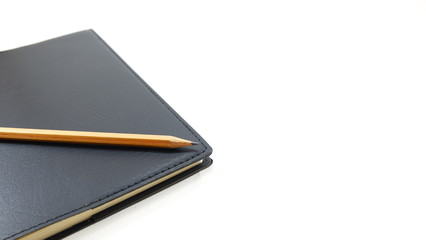 Black notebooks and wooden pencils are placed on the table.