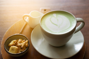 Coffee cup with Green Matcha latte art foam on wood table in coffee shop with copy space.Coffee is one of the most popular beverages.Improve Energy Levels and Burn Fat