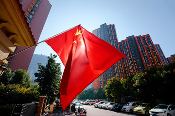 Chinese national flag in front of the modern buildings in Beijing.