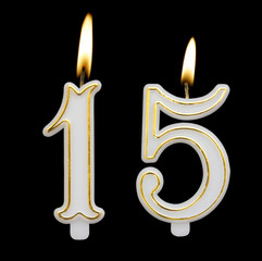 Birthday candle on black background, number 15