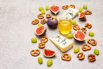 Cheese appetizer selection or wine snack set. Blue cheese, figs, honey, walnuts, pretzels