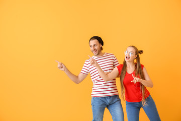 Fototapeta premium Cool young couple dancing against color background