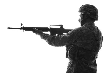 Silhouette of soldier in camouflage taking aim on white background