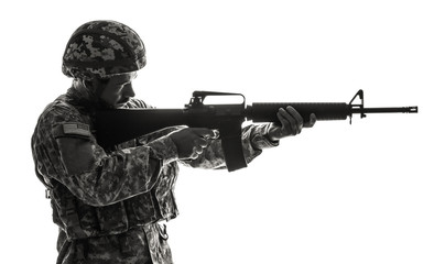 Silhouette of soldier in camouflage taking aim on white background