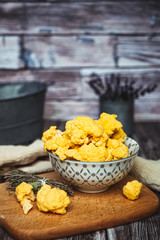 Choux fleur jaune en fleurettes dans un bol sur une table en bois	