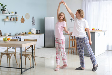 Happy young couple dancing in kitchen