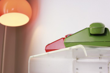 old retro telephone red green plastic isolated on white background side view front view with cable  reciever handset digits dial  Communication old fashioned classic 60s 70s