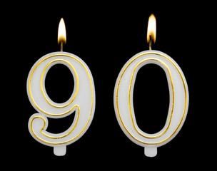 Burning birthday candle isolated on black background, number 90
