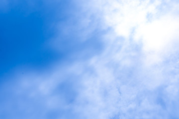 Light shining through white clouds with a blue background