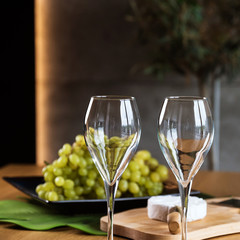 White wine with a box full of grapes on a wooden table.