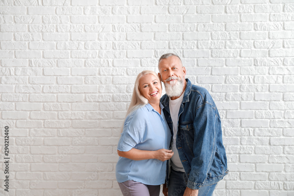 Canvas Prints happy mature couple against white brick wall