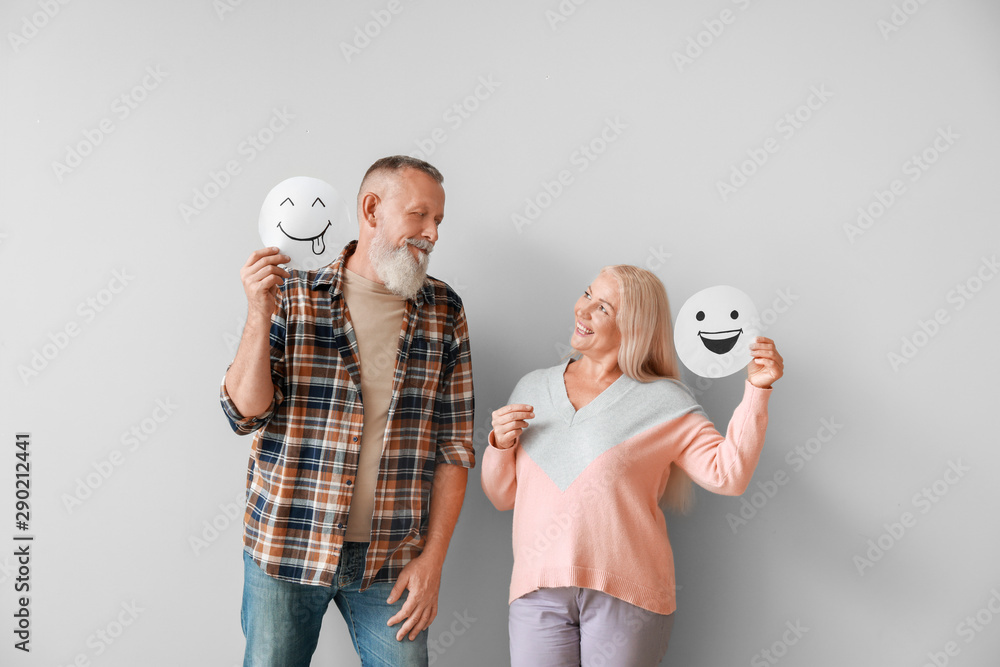 Sticker Happy mature couple with emoticons against light background