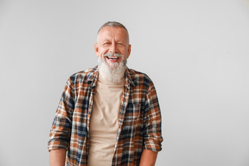 Happy mature man on grey background