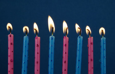 Burning birthday candles on blue background