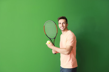 Handsome tennis player on color background