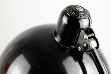 an antique black table lamp from the 20s bauhaus era standing on an old desk commode isolated on...