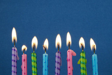 Colorful birthday candles on blue background