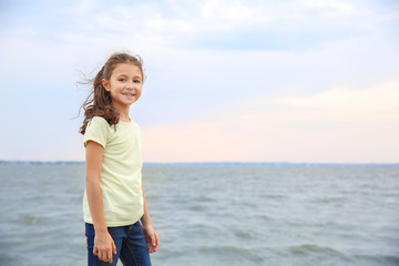 Cute little girl on river bank