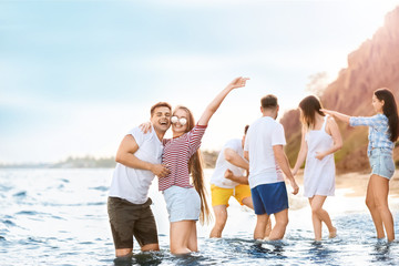 Happy friends on sea beach at resort