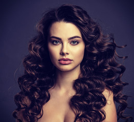 Fototapeta premium Beautiful young woman with long curly brown hair