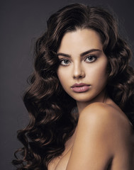 Naklejka premium Beautiful young woman with long curly brown hair