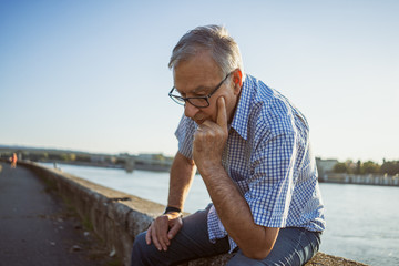 Outdoor portrait of worried and depressed senior man.